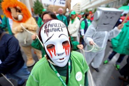 A woman wears a mask during a protest over the government's reforms and cost-cutting measures in Brussels, Belgium September 29, 2016. The mask reads "Finance Ministry worker." REUTERS/Yves Herman