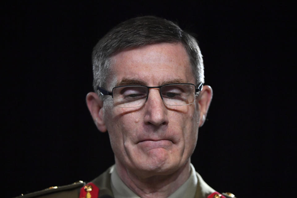 Chief of the Australian Defence Force Gen. Angus Campbell bites his lips while delivering the findings from the Inspector-General of the Australian Defence Force Afghanistan Inquiry, in Canberra, Thursday, Nov. 19, 2020. A shocking report into war crimes by elite Australian troops has found evidence that 25 soldiers unlawfully killed 39 Afghan prisoners, farmers and civilians. (Mick Tsikas/Pool Photo via AP)