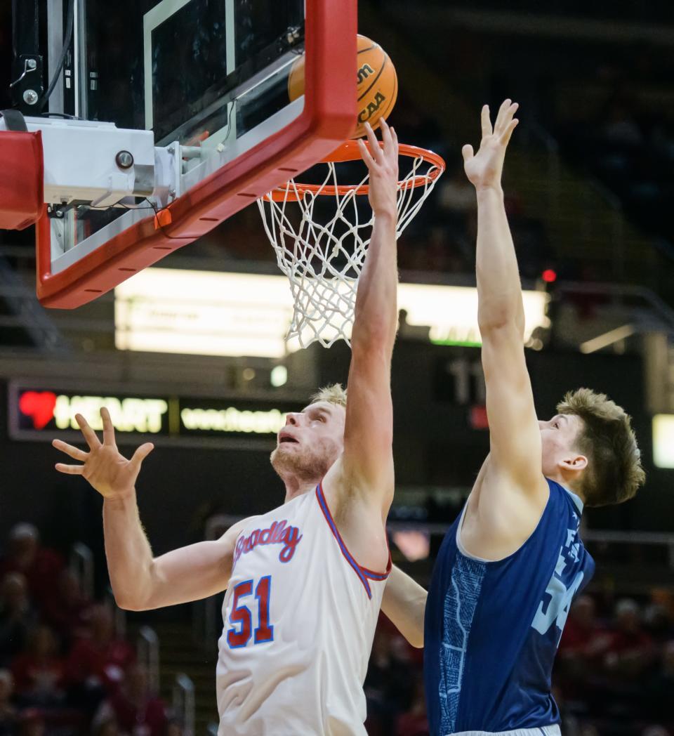 Bradley's Rienk Mast, left, puts up shot over UIC's Cameron Fens in the first half Saturday, Dec. 31, 2022 at Carver Arena. The Braves dominated the Flames 79-45.