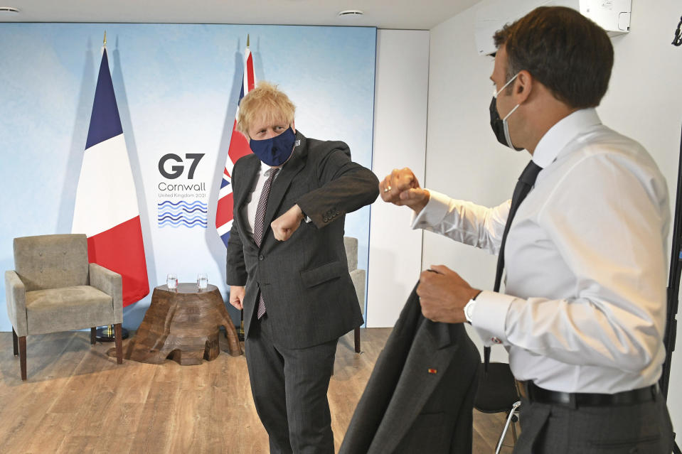 Britain's Prime Minister Boris Johnson, left, greets French President Emmanuel Macron ahead of a bilateral meeting during the G7 summit in Cornwall, England, Saturday June 12, 2021. (Stefan Rousseau/Pool via AP)