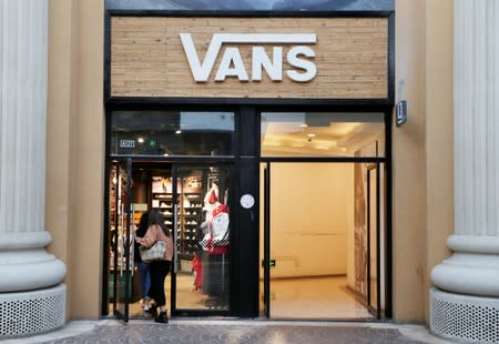 Women walk into a Vans store at a shopping center in Beijing