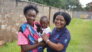 Photo credit: Elena Solana | A community case worker supports a young mother and her baby at a project site in Zambia. The Catholic Medical Mission Board (CMMB) will hold a special holy mass to commemorate the organization’s 110 years of service and to honor the invaluable work of community health workers.