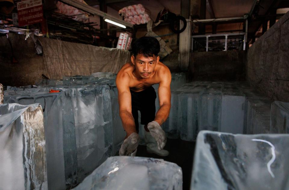 Vendors organize large blocks of ice at a chipping station at a wet market on May 01, 2024 in Bangkok, Thailand