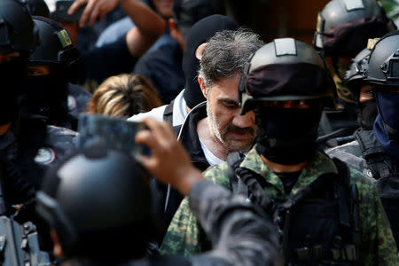 Accused drug kingpin Damaso Lopez (C), nicknamed "The Graduate", is escorted by police officers after he was arrested in Mexico City, Mexico May 2, 2017. REUTERS/Carlos Jasso