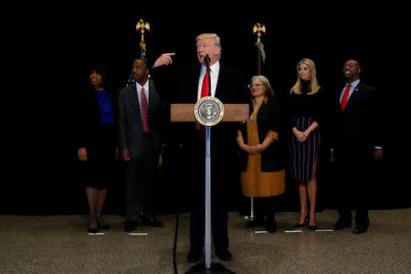 U.S. President Donald Trump is flanked by Ben Carson (2nd L), his nominee to lead the Department of Housing and Urban Development (HUD), Carson's wife, Candy Carson (L), Martin Luther King Jr's niece Alveda KIng (3rd R), Trump's daughter Ivanka Trump (2nd R), and U.S. Senator Tim Scott (R-SC) (R) as he delivers remarks after visiting the National Museum of African American History and Culture on the National Mall in Washington, U.S., February 21, 2017. REUTERS/Jonathan Ernst