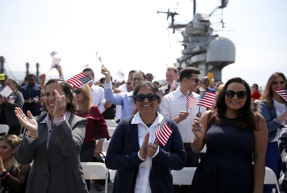 Immigrants celebrate after being sworn in as American citizens during a naturalization ceremony on the flight deck of the USS Hornet on July 3, 2018 in Alameda, California