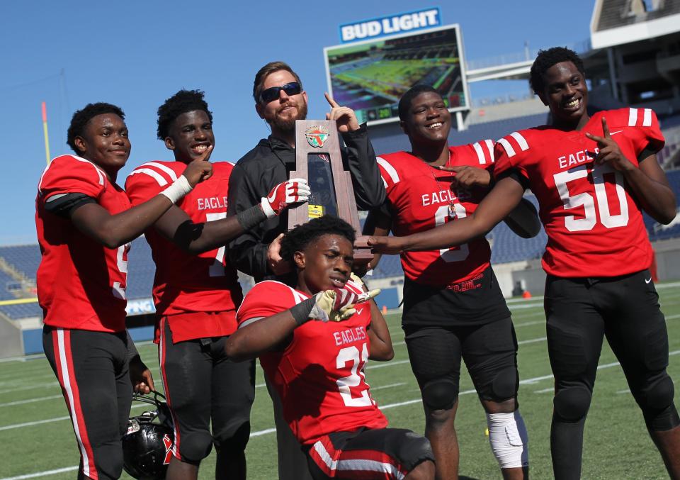 Deandrae McCray (9), T.J. Ward (7), Von Hayes (21), Quan Myrick (6), and Raymond Jackson (50) celebrate with defensive coordinator Jesse Braswell after NFC beat Champagnat Catholic 28-20 to win a Class 2A state championship on Friday, Dec. 7, 2018, at Orlando's Camping World Stadium.