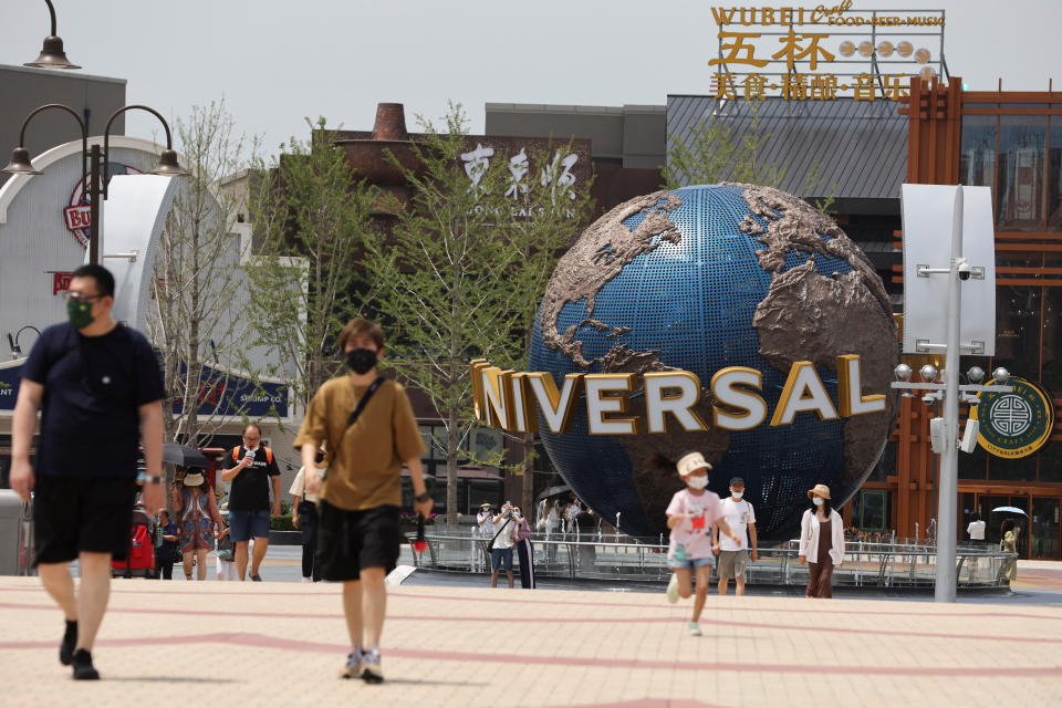 Tourists walk near an entrance to the Universal Studios theme park as it reopens to the general public, following the coronavirus disease (COVID-19) outbreak in Beijing, China June 25, 2022. REUTERS/Tingshu Wang