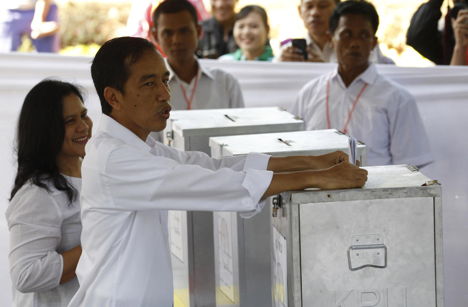 Indonesian presidential candidate Joko Widodo, front right, casts his ballot next to his wife Iriana Joko Widodo at a polling station in Jakarta, Indonesia, Wednesday, April 9, 2014. Indonesia, the world's third-largest democracy, is holding its legislative election on Wednesday. (AP Photo/Achmad Ibrahim)