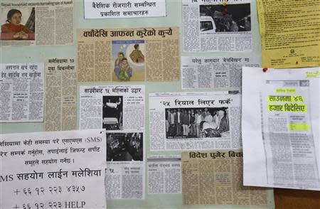 Newspaper clippings on foreign employment and the Nepalis' plights while working abroad are posted on a notice board at the Foreign Employment Promotion Board in Kathmandu October 1, 2013. REUTERS/Navesh Chitrakar