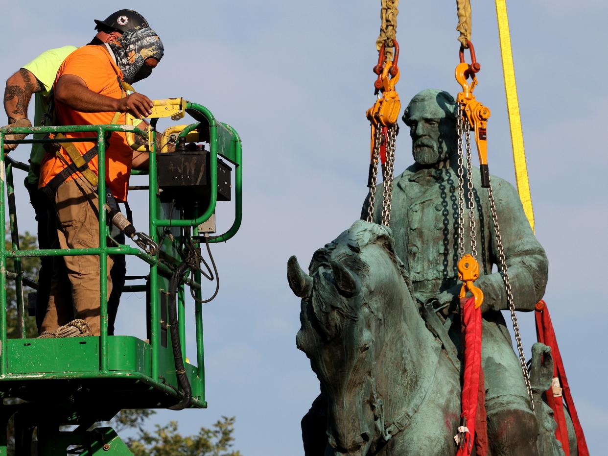 Workers remove a statue of Confederate General Robert E. Lee from Market Street Park July 10, 2021 in Charlottesville, Virginia. (Getty Images)