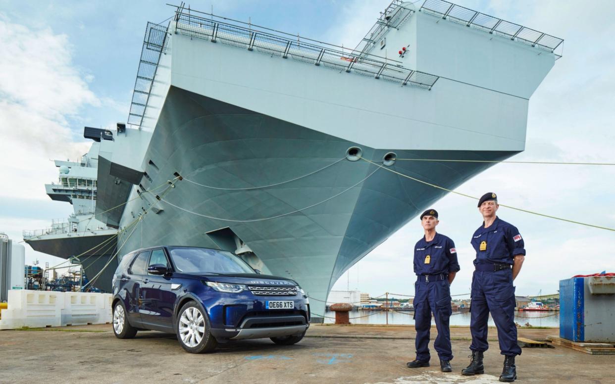 Navy captains Ian Groom and Jerry Kyd with HMS Queen Elizabeth and the Land Rover Discovery they used during their unique challenge - Matthew I Howell