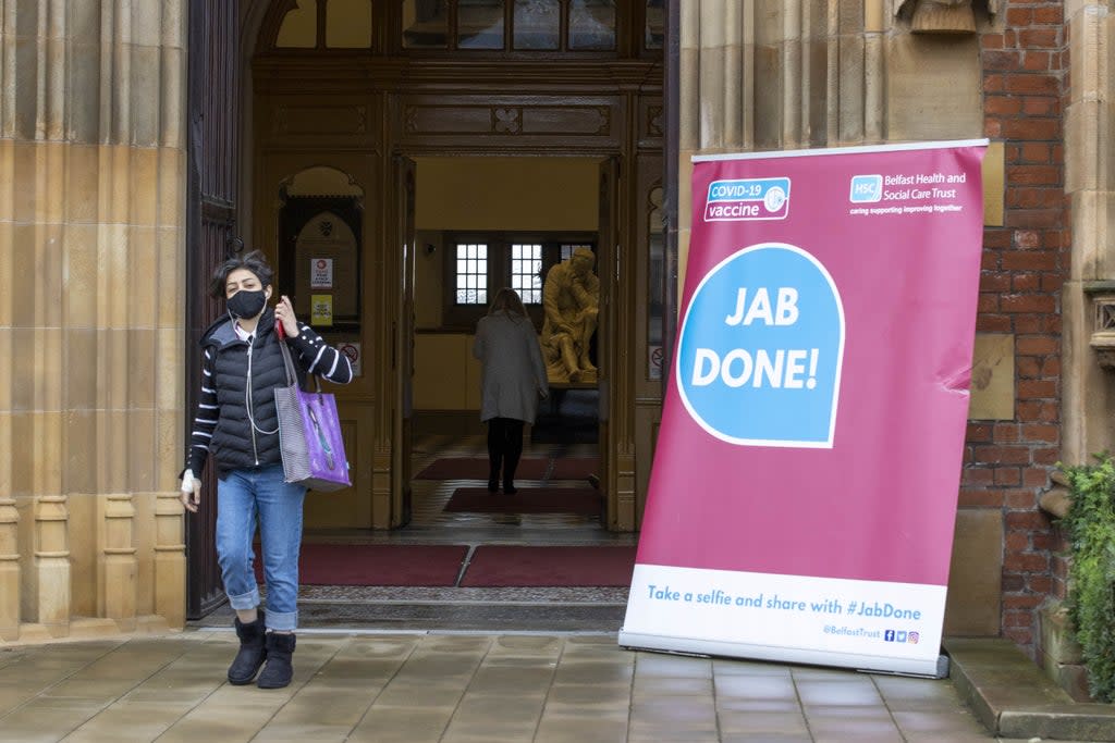 A woman walks past a Covid-19 “Jab Done!” sign at Queen’s University, Belfast (Liam McBurney/PA) (PA Wire)