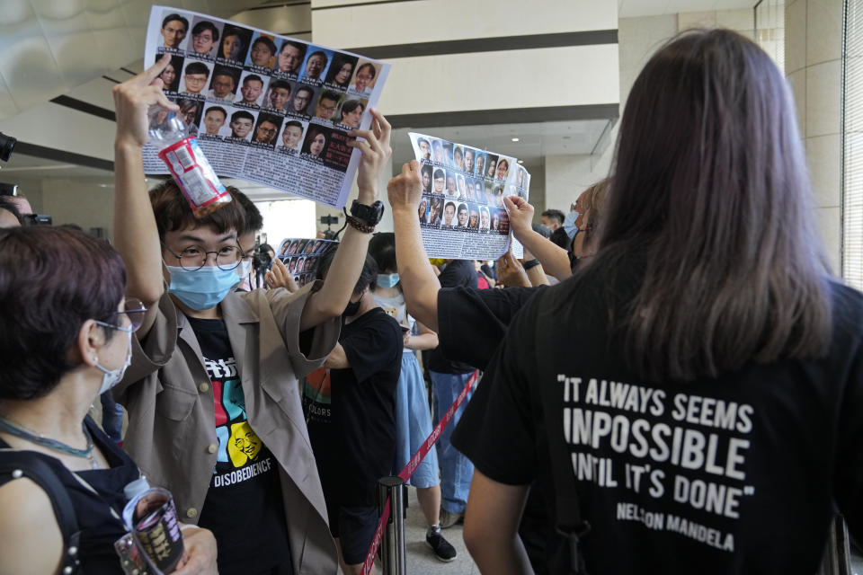 Supporters hold placards with the photos of some of the 47 pro-democracy defendants outside a court in Hong Kong, Thursday, July 8, 2021. A court hearing for 47 pro-democracy activists charged with conspiracy to commit subversion under the security law over their involvement in an unofficial primary election last year that authorities said was a plot to paralyze Hong Kong's government. (AP Photo/Kin Cheung)