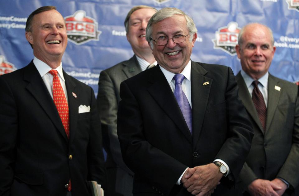 Charles Steger, center, president of Virginia Tech, smiles with Gary Ransdell, left, president of Western Kentucky, Duane Nellis, president of Idaho, and Bernie Machen, president of Florida, during a media availability after a BCS presidential oversight committee meeting, Tuesday, June 26, 2012, in Washington. A committee of university presidents on Tuesday approved the BCS commissioners' plan for a four-team playoff to start in the 2014 season. (AP Photo/Alex Brandon)