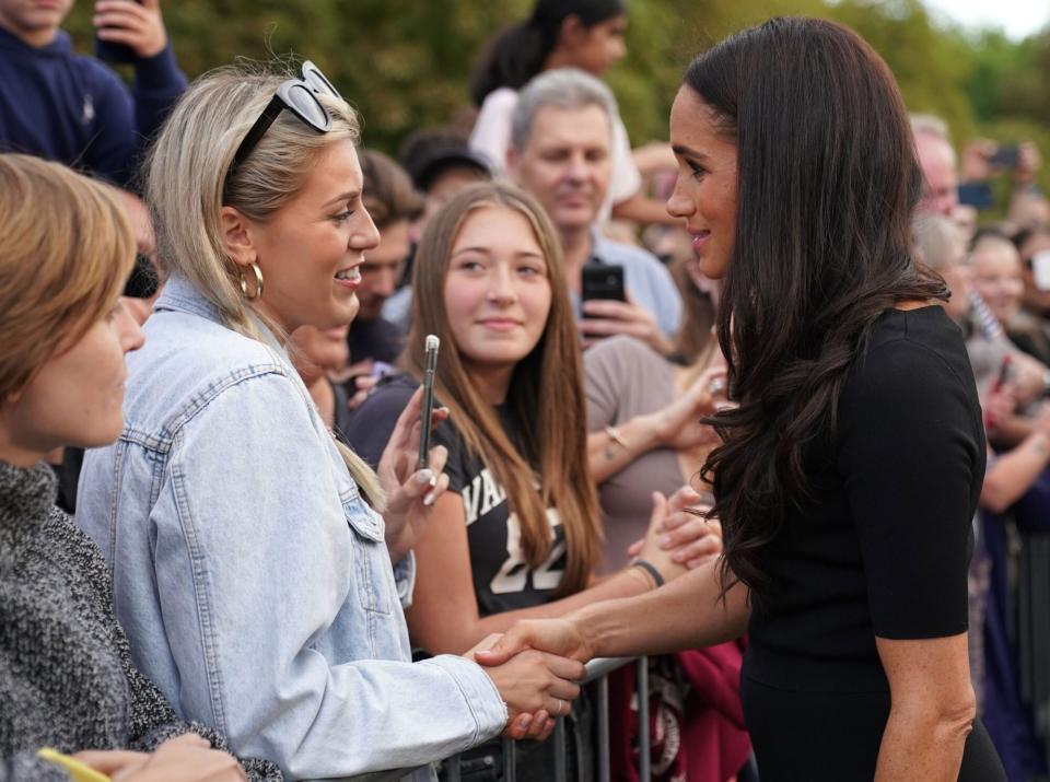 WINDSOR, ENGLAND - SEPTEMBER 10: Meghan, Duchess of Sussex meet members of the public at Windsor Castle on September 10, 2022 in Windsor, England. Crowds have gathered and tributes left at the gates of Windsor Castle to Queen Elizabeth II, who died at Balmoral Castle on 8 September, 2022. (Photo by Kirsty O'Connor - WPA Pool/Getty Images)