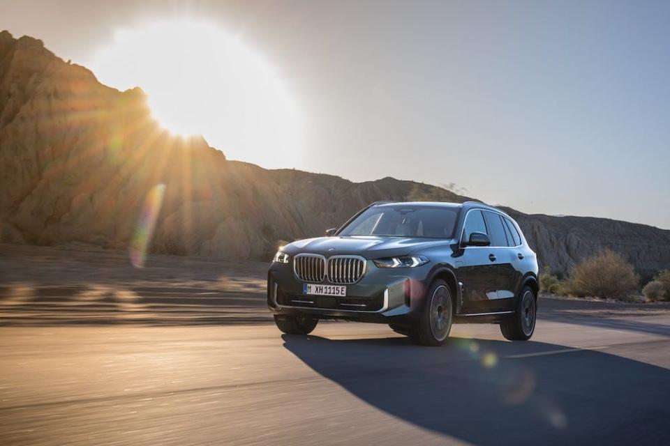 2024 BMW X5 xDrive50e drives on a sunny road