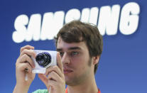 BERLIN, GERMANY - AUGUST 30: A visitor tries out the new Samsung Galaxy Camera, which combines a smartphone and a digital camera with a zoom lens, during a press day at the Samsung stand at the IFA 2012 consumer electronics trade fair on August 30, 2012 in Berlin, Germany. IFA 2012 will be open to the public from August 31 through September 5. (Photo by Sean Gallup/Getty Images)