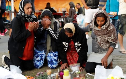 Family members from Fiji visit a memorial site for victims of Friday's shooting, in front of Christchurch Botanic Gardens in Christchurch - Credit: Reuters