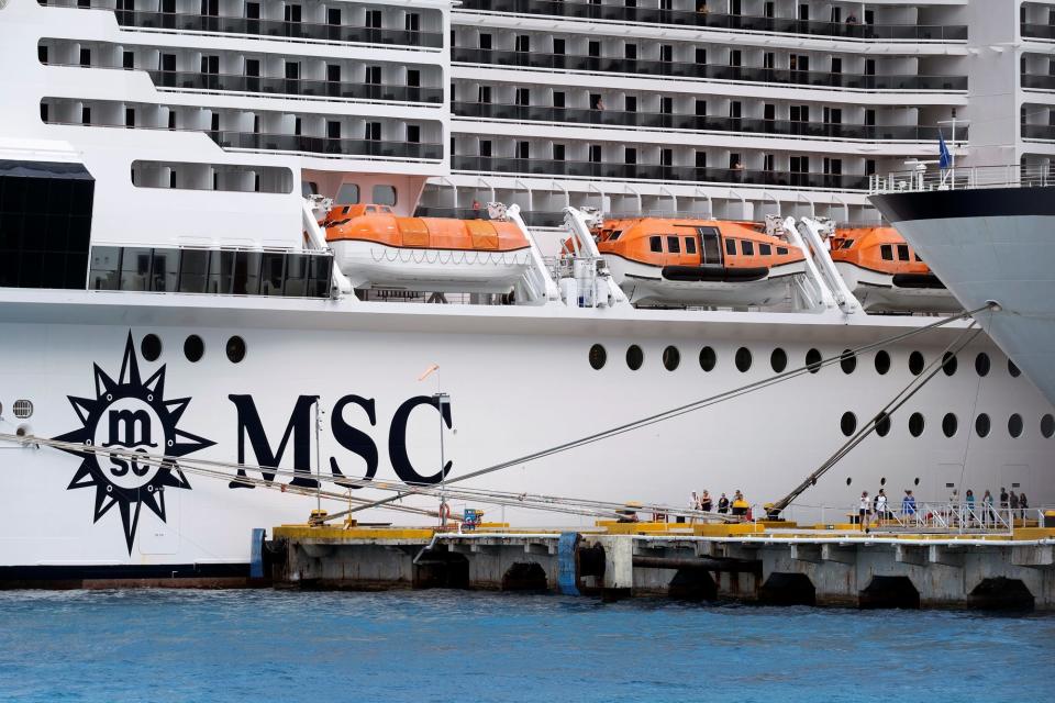 12 Tourists stand next to Cruise liner MSC Meraviglia, berthed at a dock in Punta Langosta, in Cozumel