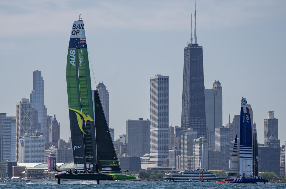 In this photo provided by SailGP, Australia's SailGP Team, France's SailGP Team, and the United States' SailGP Team sail past the Navy Pier and Chicago skyline during the United States Sail Grand Prix sailing race in Chicago, Sunday, June 19, 2022. (Bob Martin/SailGP via AP)