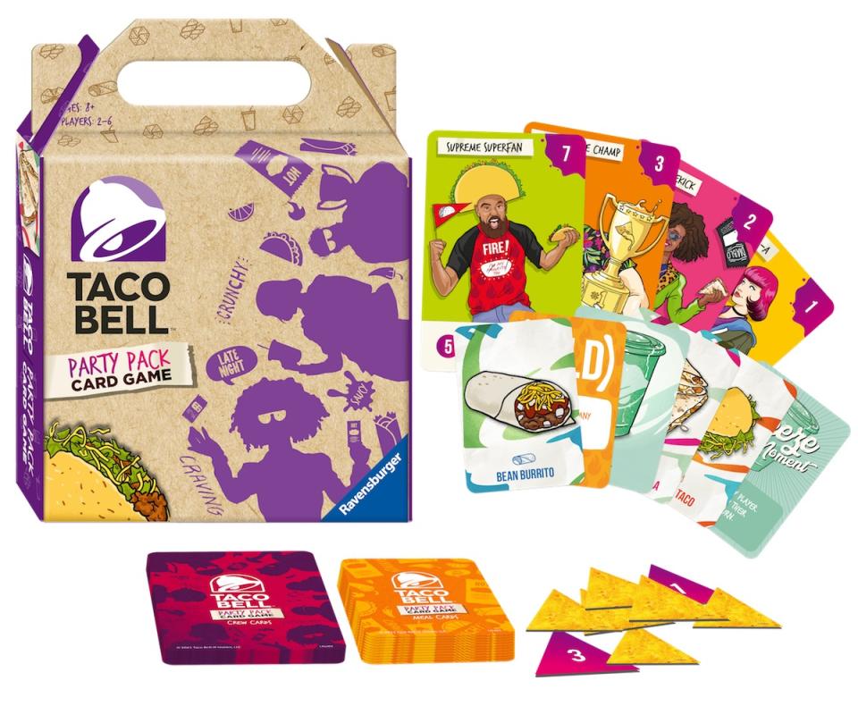 A cardboard Taco Bell carry put box for a board game next to and above cards with cartoons and art on them