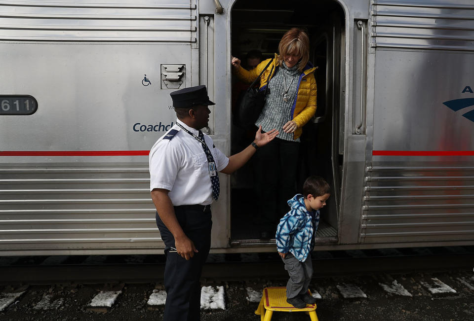 Conductor helping passengers disembark train