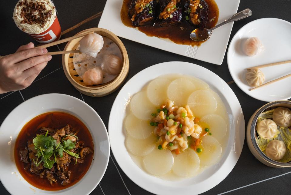 Clockwise from bottom left: braised beef brisket and bamboo shoots, tea with cream cheese foam, shrimp dumplings, stuffed eggplant, Shanghai soup dumplings and baked shrimp ball with radish