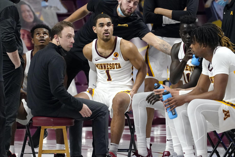 Minnesota head coach Richard Pitino, left, holds a conference with his team during a timeout in the first half of an NCAA college basketball game against Rutgers, Saturday, March 6, 2021, in Minneapolis. (AP Photo/Jim Mone)