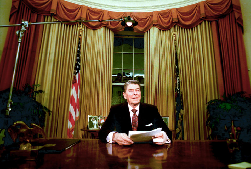 FILE - In this Jan. 11, 1989, file photo departing President Ronald Reagan sits in the Oval Office after he delivered his farewell address to the nation in the White House in Washington, on Wednesday, Jan. 11, 1989. (AP Photo/Ron Edmonds, File)