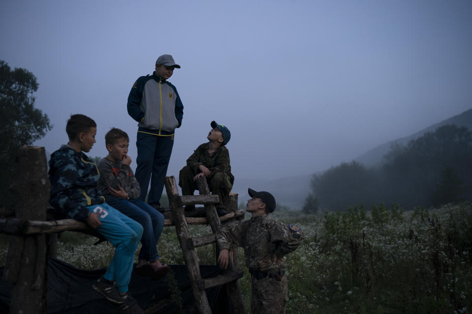 In this July 27, 2018 photo, young participants of the "Temper of will" summer camp, organized by the nationalist Svoboda party, gather in-between exercises in a village near Ternopil, Ukraine. (AP Photo/Felipe Dana)