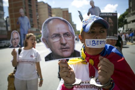 FILE PHOTO: Supporters of arrested Caracas metropolitan mayor Antonio Ledezma hold up a cutout of his face during a gathering in his support in Caracas, Venezuela, August 19, 2015. REUTERS/Marco Bello/File Photo