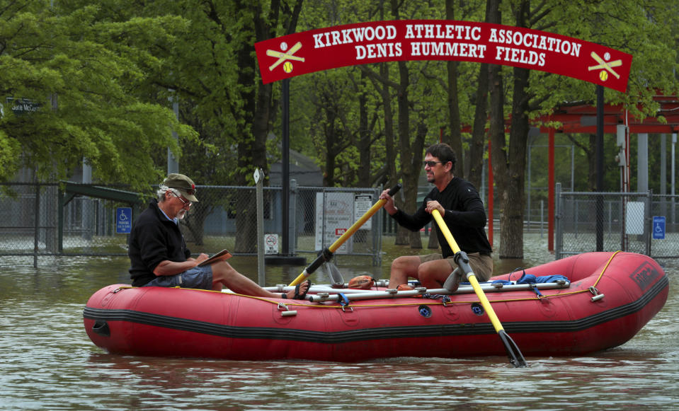 Dan Macheca (right) and Mitch Wieldt get their paddling in as they row along Marshall Road in Meramec River flood water, passing the Kirkwood Athletic Association baseball and softball fields near Greentree Park on Friday, May 3, 2019. The river sits at moderate flood stage but will rise more than four more feet before cresting right at major flood stage early Sunday, an estimated 25.1 feet. The men are training for a 280-mile rafting trip through the Grand Canyon on the Colorado River. (Robert Cohen/St. Louis Post-Dispatch via AP)