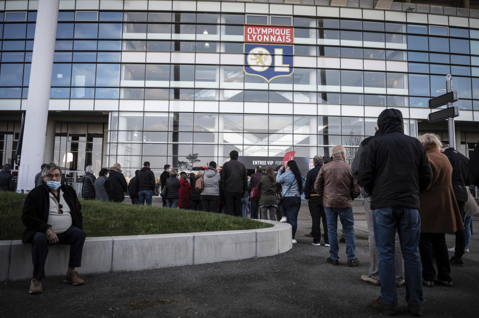 People wait outside as they arrive to be vaccinated against Covid-19 the opening day of a mass vaccination centre set up in the Olympique Lyonnais soccer Stadium, in Decines-Charpieu, Saturday, April 3, 2021. (Jean-Philippe Ksiazek, Pool via AP)