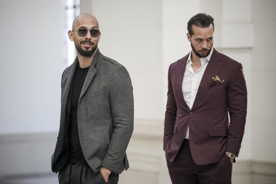 Andrew Tate, left, and his brother Tristan, right, wait inside the Court of Appeals building in Bucharest, Romania, Tuesday, Jan. 30, 2024. (AP Photo/Vadim Ghirda)