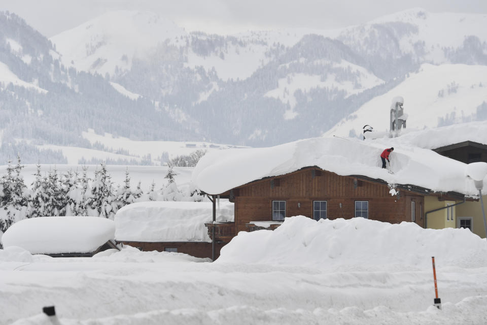 A man cleans snow from a roof on Saturday, Jan. 12, 2019 in St. Jakob, Austrian province of Tyrol.(AP Photo/Kerstin Joensson)