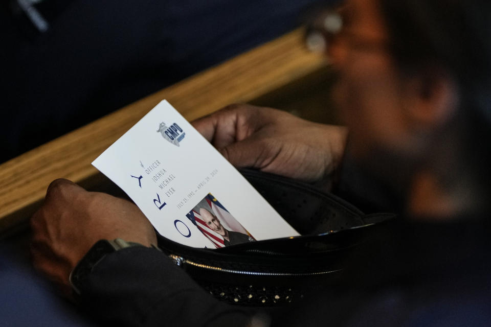 A mourner listens to a eulogy during a memorial service for Officer Joshua Eyer, Friday, May 3, 2024, in Charlotte, N.C. Police in North Carolina say a shootout that killed Eyer and wounded and killed other officers began as officers approached a home to serve a felony warrant on Monday. (AP Photo/Chris Carlson)