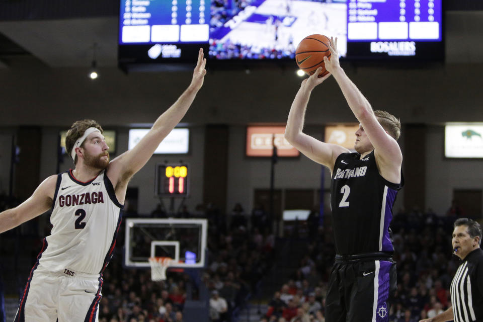 Portland guard Tyler Robertson, right, shoots while defended by Gonzaga forward Drew Timme during the first half of an NCAA college basketball game, Saturday, Jan. 14, 2023, in Spokane, Wash. (AP Photo/Young Kwak)