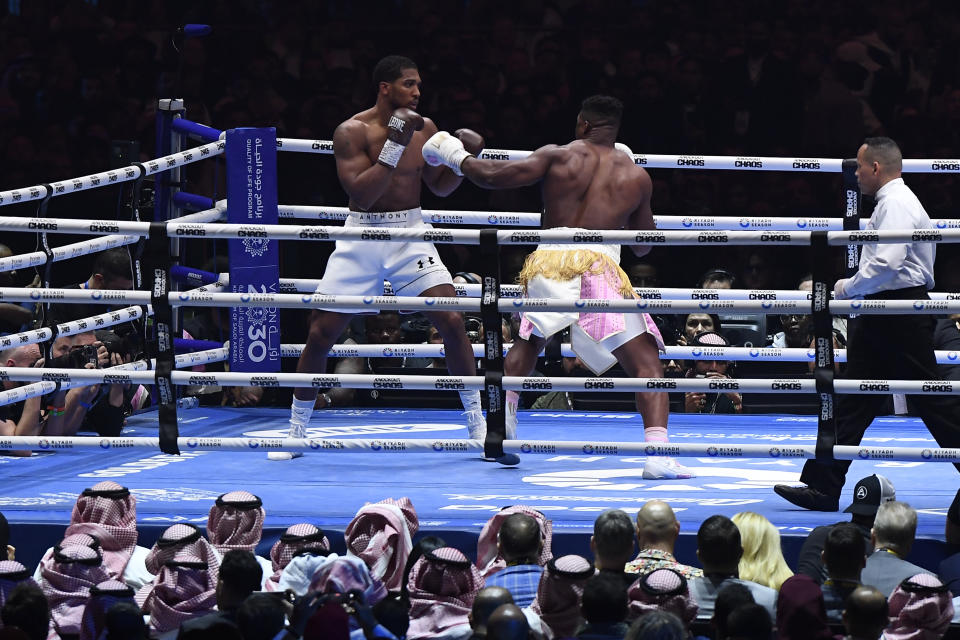 British former world champion Anthony Joshua, left, and MMA fighter Francis Ngannou fight during the heavyweight boxing showdown at Kingdom Arena in Riyadh, Saudi Arabia, Saturday, March 9, 2024. (AP Photo)