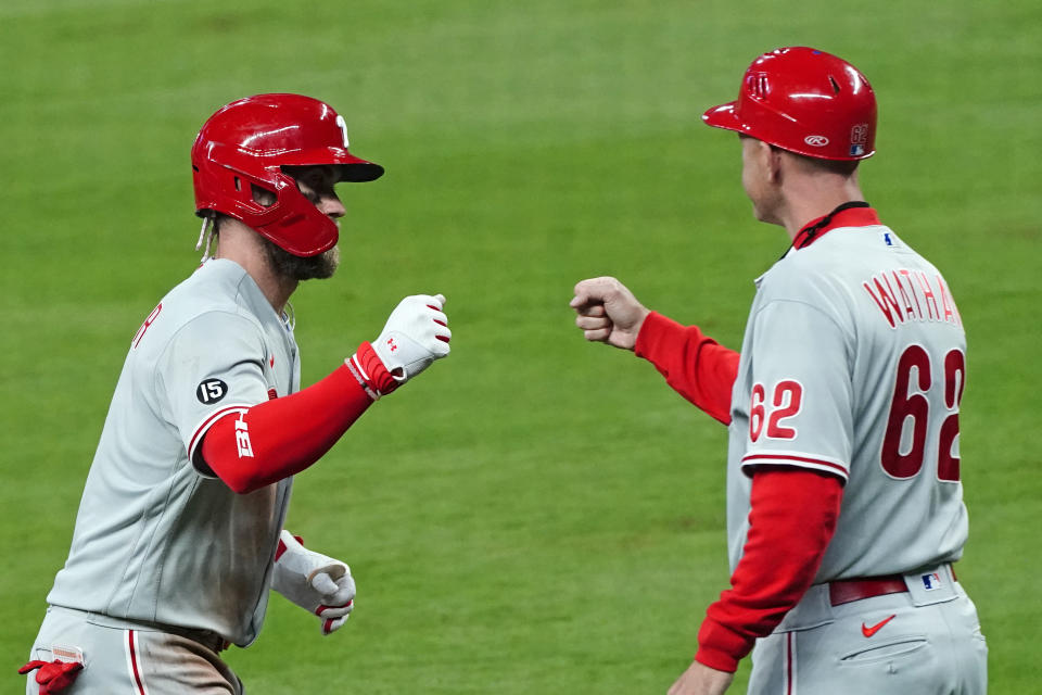 Philadelphia Phillies' Bryce Harper (3) celebrates with third base coach Dusty Wathan (62) as he rounds third base after hitting a home run in the sixth inning of a baseball game against the Atlanta Braves, Saturday, April 10, 2021, in Atlanta. (AP Photo/John Bazemore)