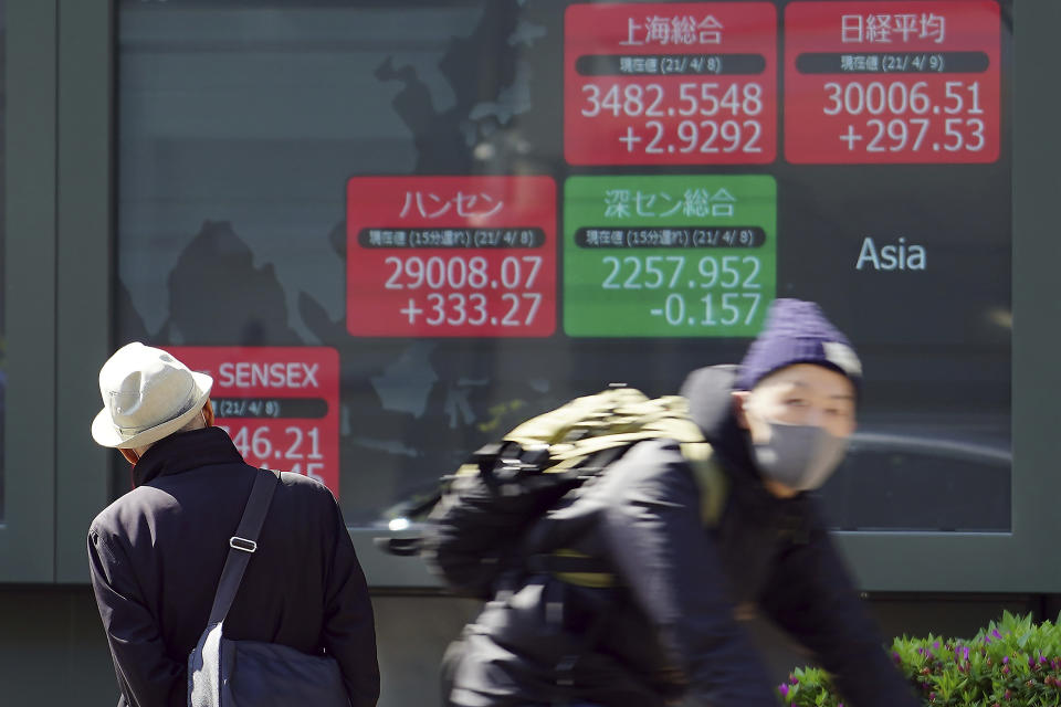 A man looks at an electronic stock board showing Japan's Nikkei 225 and the Asian indexes at a securities firm in Tokyo Friday, April 9, 2021. Shares fell Friday in most Asian markets after China reported a stronger than expected rise in prices that could prompt authorities to act to cool inflation. (AP Photo/Eugene Hoshiko)