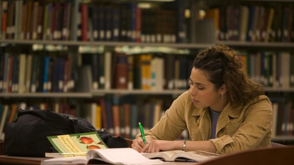 Una joven estudiando.