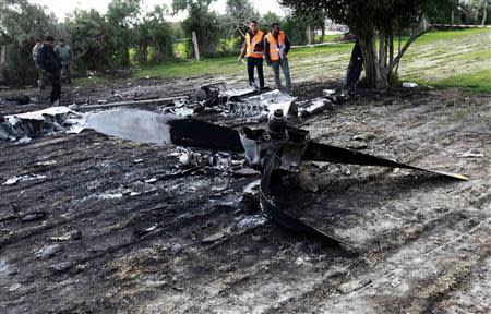 Investigators work at the site of a plane crash near Grombalia town, south of Tunis, February 21, 2014. REUTERS/Anis Mili