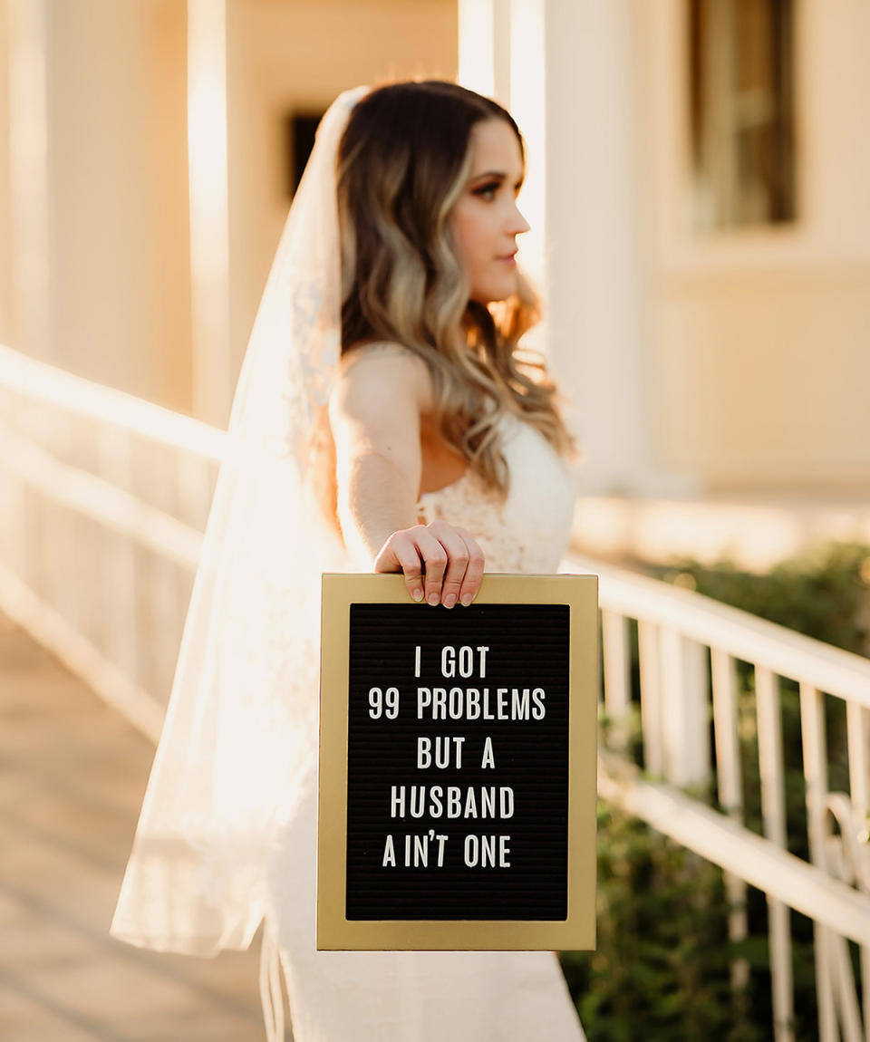 Woman in a wedding dress holding up a sign