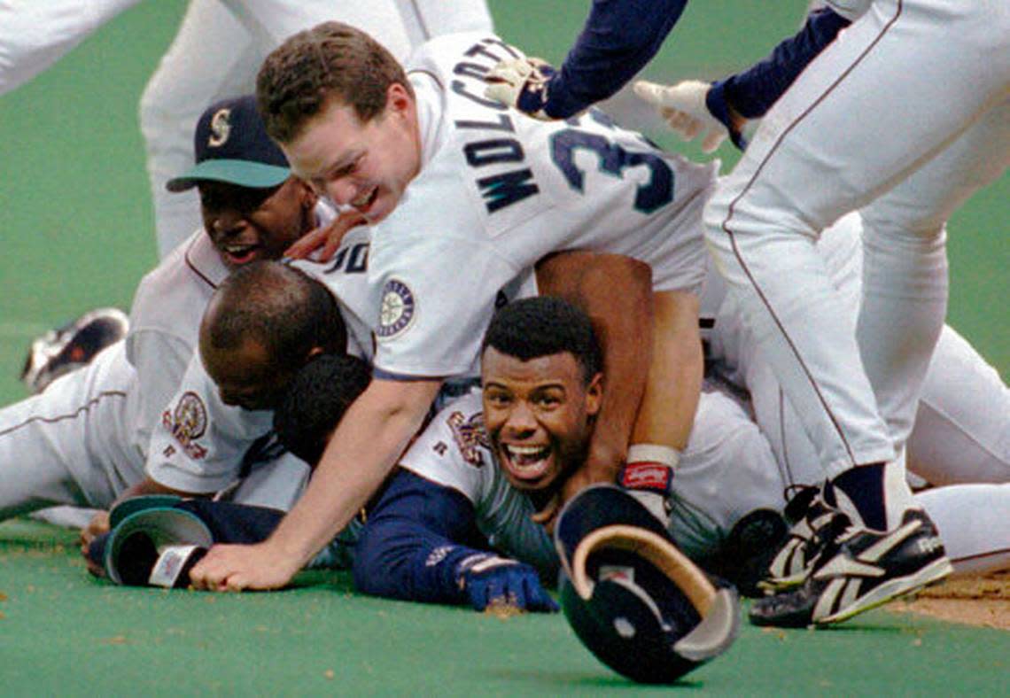 FILE - In this Oct. 8, 1995, file photo, Seattle Mariners’ Ken Griffey Jr. smiles from beneath a pile of teammates who mobbed him after he scored the winning run in the bottom of the 11th inning of a baseball game against the New York Yankees, in Seattle. The Seattle Mariners are the only baseball franchise never to advance to the Fall Classic. Baseball has never been played in Seattle beyond Oct. 22. The Mariners have three times been to the American League Championship Series, and all three times were sent home before there could ever be a Game 7.(AP Photo/Elaine Thompson, File)