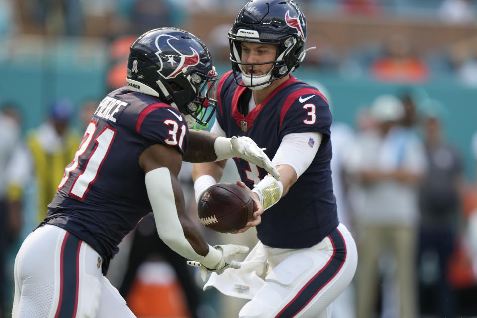 Houston Texans quarterback Kyle Allen (3) hands the ball to running back Dameon Pierce (31) during the first half of an NFL football game, Sunday, Nov. 27, 2022, in Miami Gardens, Fla. (AP Photo/Lynne Sladky)