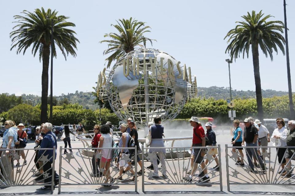 This photo taken Wednesday, June 5, 2013, show tourists lining up at the normal line at Universal Studios Hollywood in Los Angeles. Many theme parks now have VIP tours with perks usually reserved for celebrities _ private tour guides, no waits for the biggest attractions, reserved seating at shows and parades along with behind-the-scenes peaks at places normally off limits. (AP Photo/Damian Dovarganes)