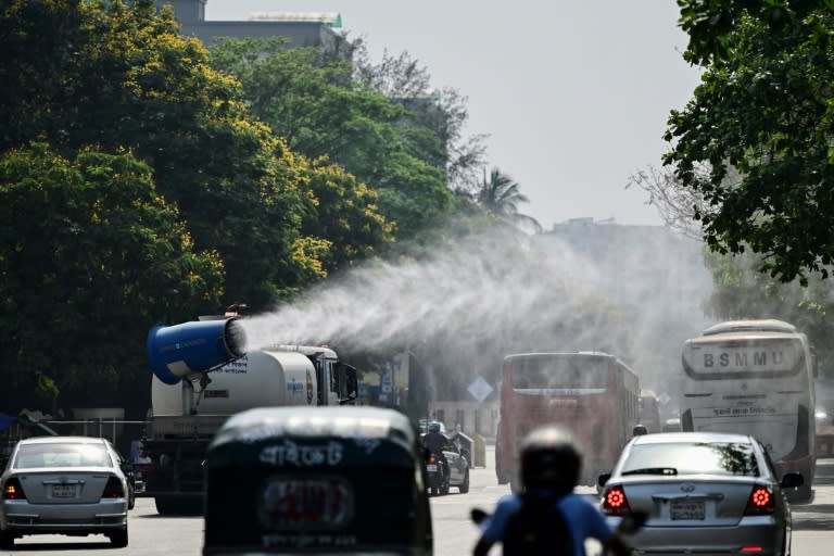 Un vehículo municipal rocía agua en una transitada calle de Daca para combatir la ola de calor, el 27 de abril de 2024 en la capital de Bangladés (Munir Uz Zaman)