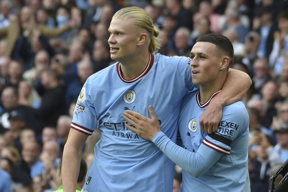 Manchester City's Phil Foden, right, celebrates with his teammate Erling Haaland after scoring his side's sixth goal and his personal hat trick during the English Premier League soccer match between Manchester City and Manchester United at Etihad stadium in Manchester, England, Sunday, Oct. 2, 2022. (AP Photo/Rui Vieira)