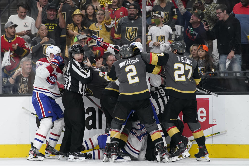 Referees attempt to break up a shoving match during the second period in Game 2 of an NHL hockey Stanley Cup semifinal playoff series between the Vegas Golden Knights and the Montreal Canadiens, Wednesday, June 16, 2021, in Las Vegas. (AP Photo/John Locher)